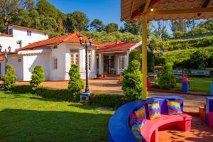 a house with a yard with a chair and a swing at goSTOPS Ooty in Ooty