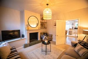 a living room with a couch and a mirror at Nadder Lodge - Salisbury in Old Sarum