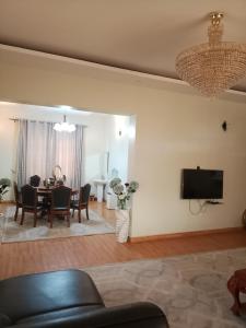 a living room with a table and a tv on a wall at Same Harmony Hideaway in Zame