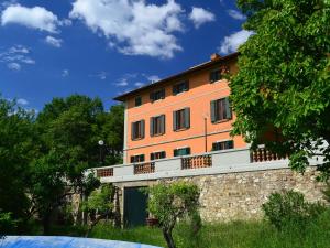 an orange building with a balcony on top of a wall at Peaceful Holiday Home with Pool in Montefiridolfi Italy in Montefiridolfi