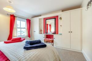 a bedroom with a bed with red and blue pillows on it at 2 Bed in Mundesley oc-1353 in Mundesley