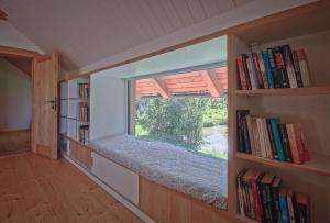 a room with a window and a book shelf with books at Příchvoj 8 Český ráj in Sobotka