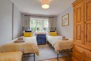 a bedroom with two beds with yellow pillows at 2 Bed in Aldborough oc-2174 in Thurgarton
