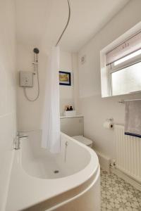 a white bathroom with a tub and a toilet at 2 Bed in Aldborough oc-2174 in Thurgarton +21 photos