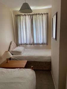 a bedroom with two beds and a window at Bolthole in Hayle