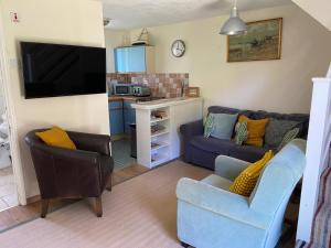 a living room with a couch and a kitchen at Bolthole in Hayle
