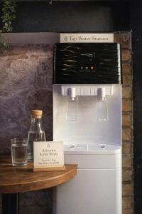 a refrigerator next to a table with a bottle of water at Kuyu Beergarden Hostel in Antalya