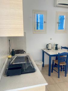 a kitchen with a sink and a kitchen table at Iosub Houses & Studios - Cosy Seaside House in Koumbara in Tzamaria +36 photos