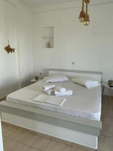 a white bed with towels on it in a bedroom at Iosub Houses & Studios - Cosy Seaside House in Koumbara in Tzamaria