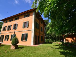 a large house in a yard with a tree at Peaceful Holiday Home with Pool in Montefiridolfi Italy in Montefiridolfi