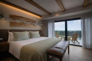 a bedroom with a large bed and a large window at Casa Pradera - Hotel Serrano in Sierra de los Padres