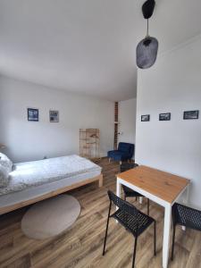 a bedroom with a bed and a table and chairs at Roland Apartamenty in Świeradów-Zdrój