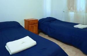 two beds with blue sheets in a room at Habitación en 25 N 2 in Veinticinco de Mayo
