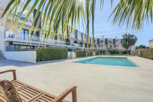 a chair and a swimming pool in front of a building at La Perla 6 in Port de Pollensa