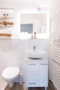 a white bathroom with a sink and a toilet at modernes Apartment bei Schlosspark Nymphenburg, Top Verkehrsanbindungen, free parking, perfekt für Business- City-Trips und Events in Munich +10 photos