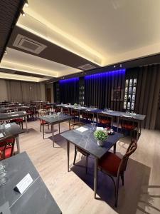 a dining room with tables and chairs and blue lights at Confidence Hotel Europa in Cento