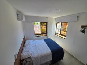 a small bedroom with a bed and two windows at Conforto e Sofisticação à Beira Mar in Cabedelo +79 photos
