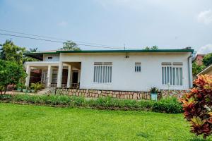 a white house with a green yard at Nazareth Guest House in Kigali
