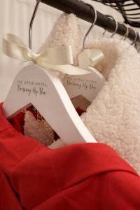 a red dress on a hanger with a piece of paper at The little Hotel-luxury home in Motcombe