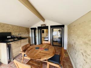 a room with a wooden table and a kitchen at La tour de Grignan in Grignan