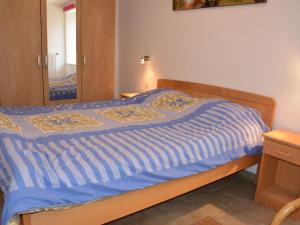 - un lit avec une couette bleue dans une chambre dans l'établissement Rural lodging located in the small village of Radelange 100 Nature, à Radelange