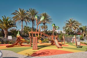 a park with a playground with slides and palm trees at Seaside Los Jameos in Puerto del Carmen