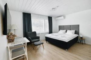 a bedroom with a bed and a desk and a chair at Katariina Apartments in Kotka