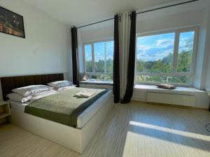 a bedroom with a bed and a large window at ZOOM Apartments - Budapest in Budapest