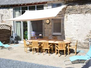 uma mesa e cadeiras de madeira com um guarda-sol branco em Rural lodging located in the small village of Radelange 100 Nature em Radelange