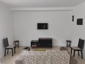a living room with a couch and two chairs at Casa Tia Celinha e Cafeteria in Teresópolis