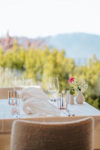 a table with a white table cloth and wine glasses at Hotel am Hang in Soprabolzano