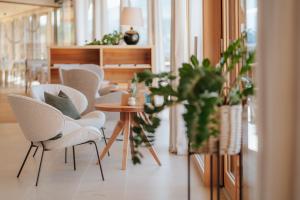 a room with chairs and a table with plants at Hotel am Hang in Soprabolzano +48 photos