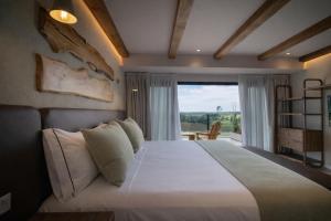 a bedroom with a large bed with a large window at Casa Pradera - Hotel Serrano in Sierra de los Padres