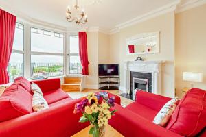 a living room with two red couches and a fireplace at 3 Bed in Woolacombe oc-clevel in Woolacombe