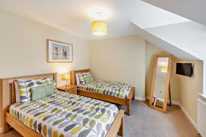 a bedroom with two beds and a mirror at 3 Bed in Woolacombe oc-clevel in Woolacombe