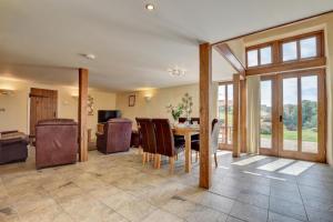 a dining room with a table and chairs and a living room at 3 Bed in Tiverton oc-thresh in Bampton