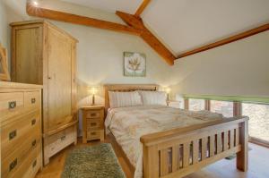 a bedroom with a large bed and a wooden cabinet at 3 Bed in Tiverton oc-thresh in Bampton