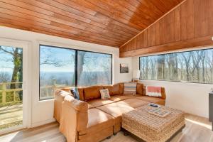 a living room with a couch and large windows at Lula Lake Cabin in Rising Fawn