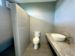 a bathroom with a white toilet and a sink at Woodview Resort in Samut Prakan