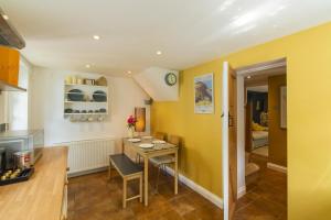 a kitchen and dining room with yellow walls and a table at 2 Bed in Lynton oc-trelyn in Lynmouth
