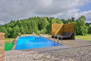 a backyard pool with a wooden deck and a swimming poolvisor at Chalupa Dolní Hedeč blízko Dolní Moravy in Horní Orlice