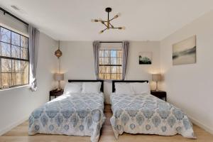two beds in a room with two windows at Lula Lake Cabin in Rising Fawn