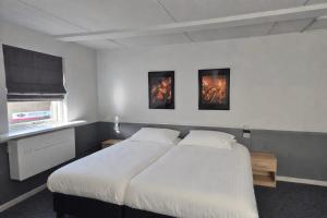 a bedroom with a bed and two paintings on the wall at Hotel,cafe,biljart POT in Groenlo +29 photos