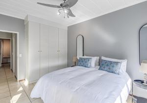 a bedroom with a large white bed with blue pillows at Via Positano 95, Paulshof in Sandton +38 photos