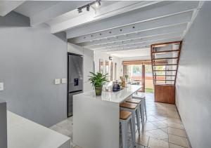 a kitchen with a white counter and stools at Via Positano 95, Paulshof in Sandton