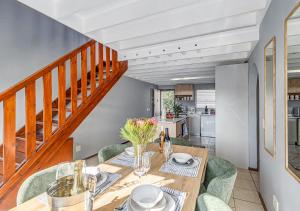 a dining room with a table and chairs and a staircase at Via Positano 95, Paulshof in Sandton