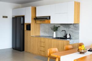 a kitchen with white cabinets and a wooden table at Manse 만세 Villa in Ciburial