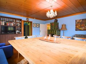 ラムにあるSpacious Villa near Forest in Buchetのダイニングルーム(大きな木製テーブル、シャンデリア付)