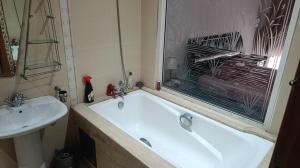 a bathroom with a bath tub and a sink at Beautiful Apartment Hamria in Meknès +13 photos
