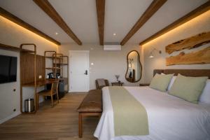 a bedroom with a large white bed and a desk at Casa Pradera - Hotel Serrano in Sierra de los Padres
